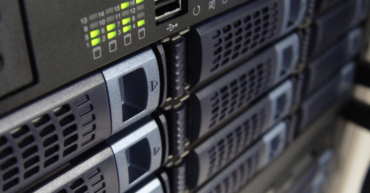 Close-up of several server racks with illuminated status lights, showcasing the NCS difference in data center hardware components.