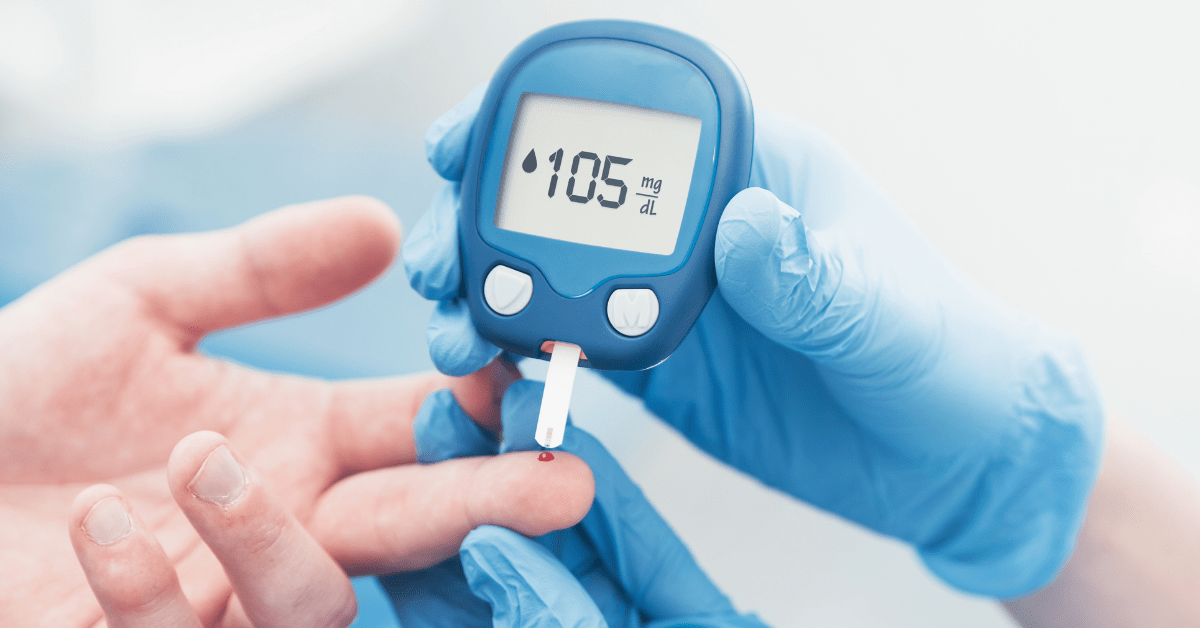 In the healthcare industry, a gloved hand uses a glucose meter to check another person's blood sugar level, displaying a reading of 105 mg/dL.