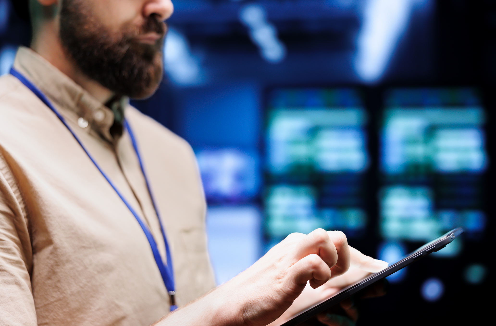 In a data center, a person navigates a tablet amid blurred server racks, staying informed about important changes in SEC regulations.