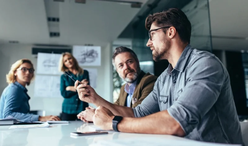 Team having a discussion around a table in a modern office meeting room