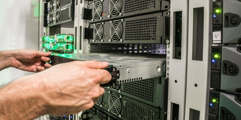 Technician installing server component in data center rack