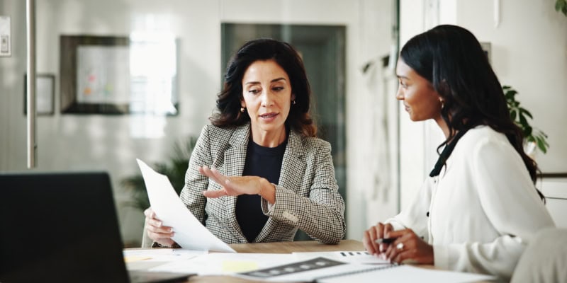 Businesswomen Discussing Documents in Modern Office Meeting