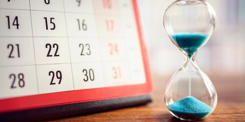 Hourglass and Calendar Showing Time Running Out for Deadlines